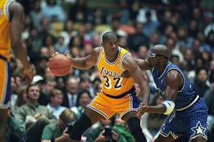 Magic Johnson of the Los Angeles Lakers with the ball as Horace Grant of the Orlando Magic defends. (Photo by Matt A. Brown/Icon Sportswire)