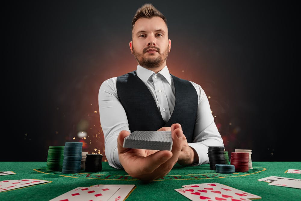 Dealer holding out deck to player.