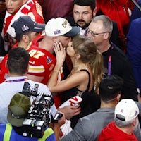 Kansas City Chiefs tight end Travis Kelce (87) kisses girlfriend Taylor Swift as he celebrates winning the game during Super Bowl LVIII between the Kansas City Chiefs and the San Francisco 49ers.