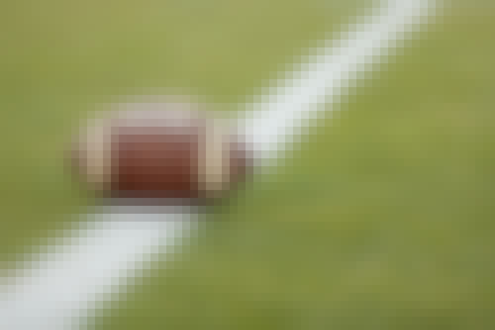 Football sitting on a yard line.