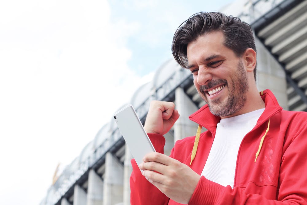 Excitment over a betting app outside of a sports stadium.