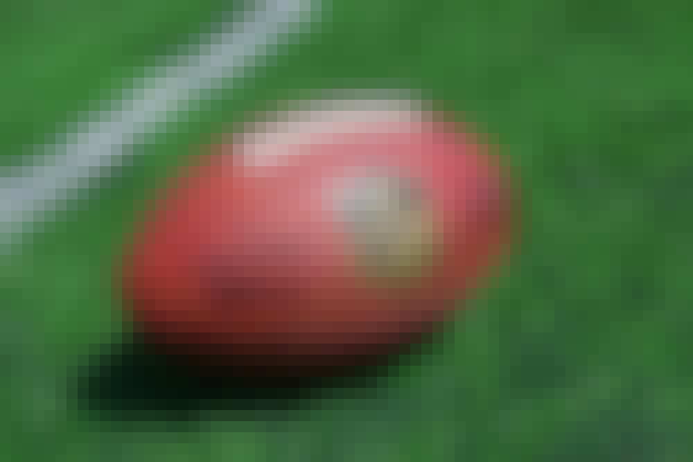 NFL ball placed on a football field near the yardline.