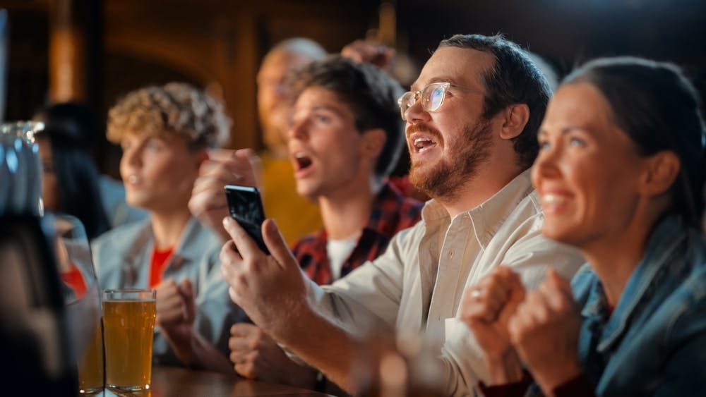 Someone sports betting and watching the game. 