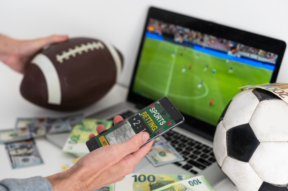 Football and Soccer ball with a computer, phone, and money. 