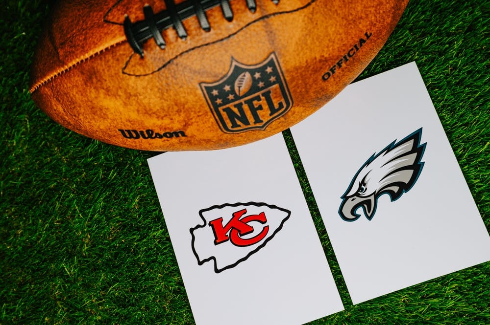 An NFL football with Kansas City Chiefs and Philadelphia Eagles cards next to it.