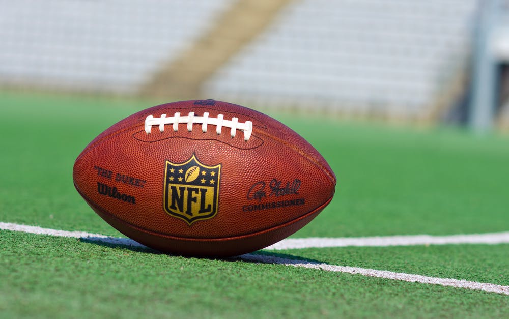 NFL ball placed on a football field. 